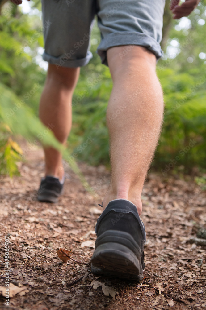 man in trekking gear walking through rocky trail man in trekking gear walking through rocky trail