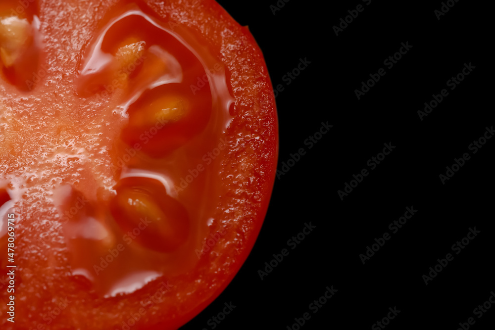 Cut section of cherry tomato on black background