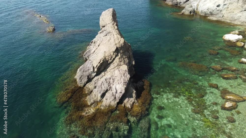 Aerial view from above on calm azure sea and volcanic rocky shores. Small waves on water surface in motion blur. Nature summer ocean sea beach background. Nobody. Holiday, vacation and travel concept