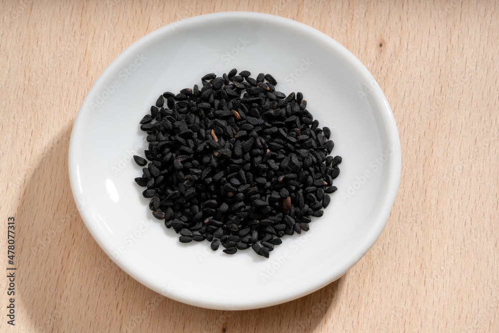 Detailed and large close up shot of nigella on a small plate Detailed and large close up shot of nigella on a small plate