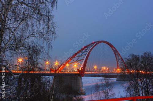 red arch of the cable-stayed bridge in winter at night in novosibirsk
