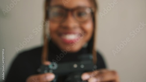 Wallpaper Mural Female photographer smiling happily while using a dslr camera. Cheerful young woman taking photographs while standing in her home studio. Torontodigital.ca