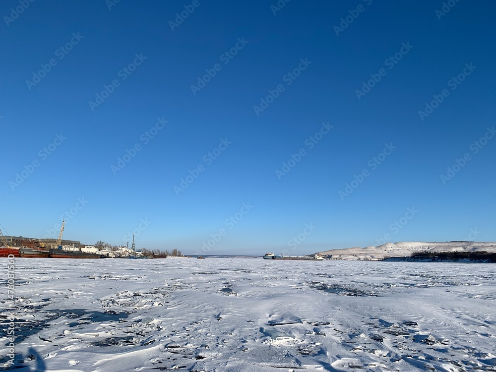 view of the port of the Volga river frozen in ice and covered with snow