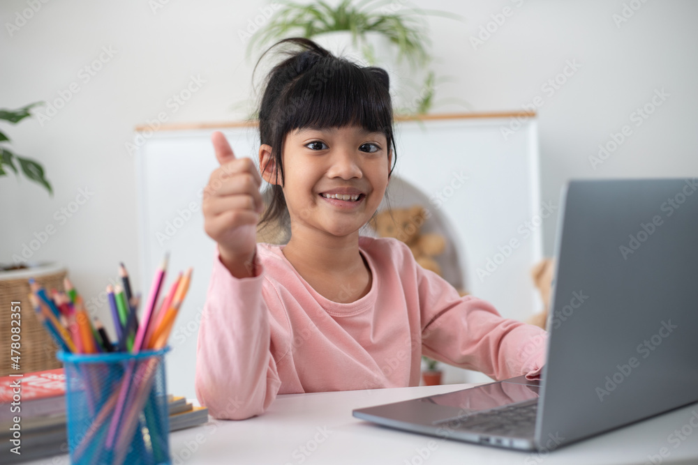 Asian girl using Laptop computer for online study homeschooling during home quarantine. homeschooling, online study, home quarantine, online learning, corona virus or education technology concept Asian girl using Laptop computer for online study homeschooling during home quarantine. homeschooling, online study, home quarantine, online learning, corona virus or education technology concept