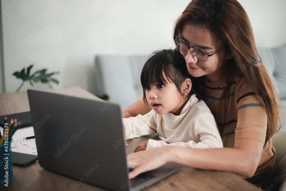 Mother working at home-office with daughter on her lap Mother working at home-office with daughter on her lap