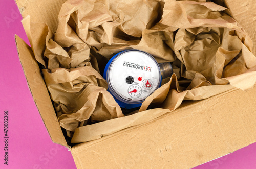 New water meter packed in wrapping paper in a cardboard box. photo