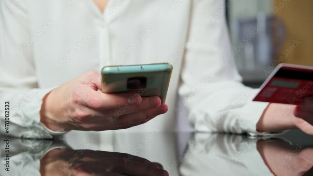 Woman holds credit card and put in payment data in smartphone to make purchase in internet shop, online shopping, e-commerce and internet banking concept