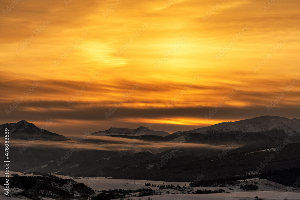 Snowy winter mountain landscape and colorful sky due sunrise over hills Sina, Dumbier and Chopok  in Low Tatras mountains at Slovakia