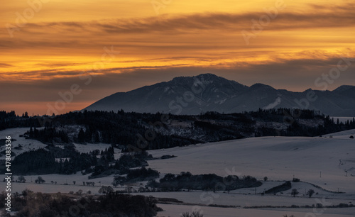 Snowy winter mountain landscape and colorful sky due sunrise over hill Poludnica in Low Tatras mountains at Slovakia photo