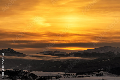 Snowy winter mountain landscape and colorful sky due sunrise over hills Sina, Dumbier and Chopok in Low Tatras mountains at Slovakia