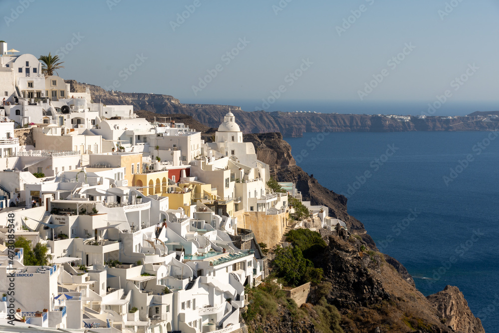 Fira, Greece - July 27, 2021: View of Fira and Church of Saint Menas in the background