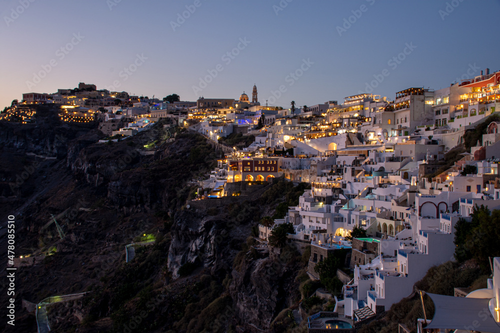 Fira, Greece - July 28, 2021: View of Fira at the cliffs during dusk