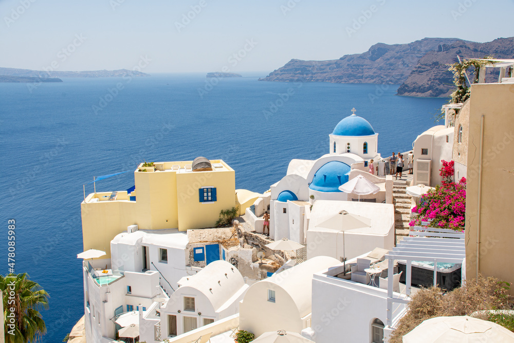 Oia, Greece - July 28, 2021: View above Oia and the Churches of St. Anastasi and St. Spirydon