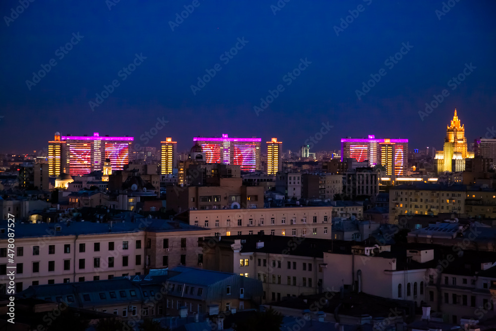 Obraz premium Evening (night) illuminated Soviet office building of Novyi Arbat on deep blue sky. Panoramic birds-eye view photo.