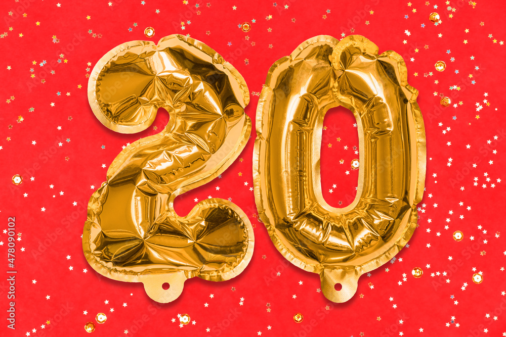 The number of the balloon made of golden foil, the number twenty on a red background with sequins. Birthday greeting card with inscription 20. Anniversary concept. Numerical digit, Celebration event. The number of the balloon made of golden foil, the number twenty on a red background with sequins. Birthday greeting card with inscription 20. Anniversary concept. Numerical digit, Celebration event.