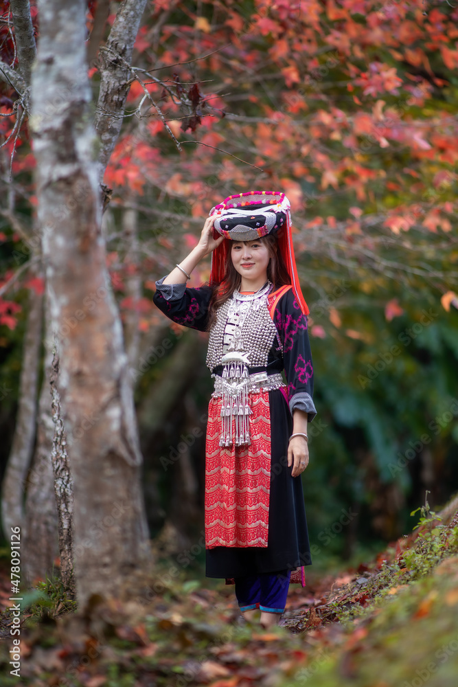 Women of Lisu Hill Tribe show colorful and beautiful traditional clothes walking in maple garden Women of Lisu Hill Tribe show colorful and beautiful traditional clothes walking in maple garden