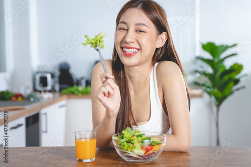 Smiled happy woman eating a bowl of salad as breakfast for good health.