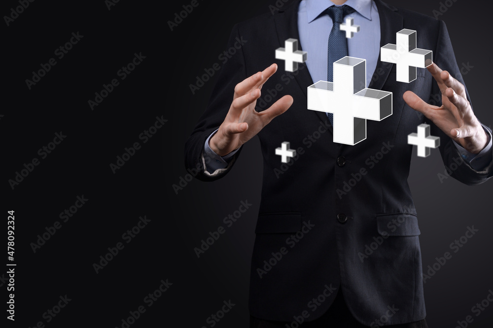 Businessman hold 3D plus icon, man hold in hand offer positive thing such as profit, benefits, development, CSR represented by plus sign.The hand shows the plus sign Businessman hold 3D plus icon, man hold in hand offer positive thing such as profit, benefits, development, CSR represented by plus sign.The hand shows the plus sign