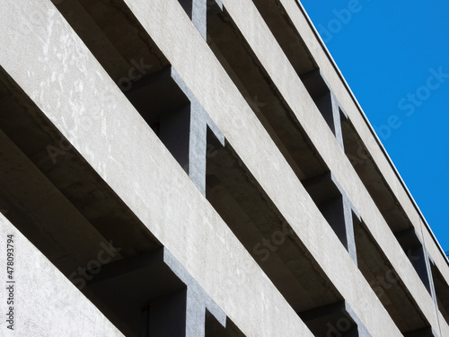 Facade of a multi-level car parking on a background of blue sky