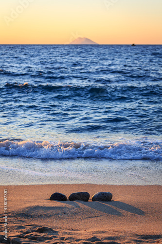 Beach at sunset with rocks in Italy