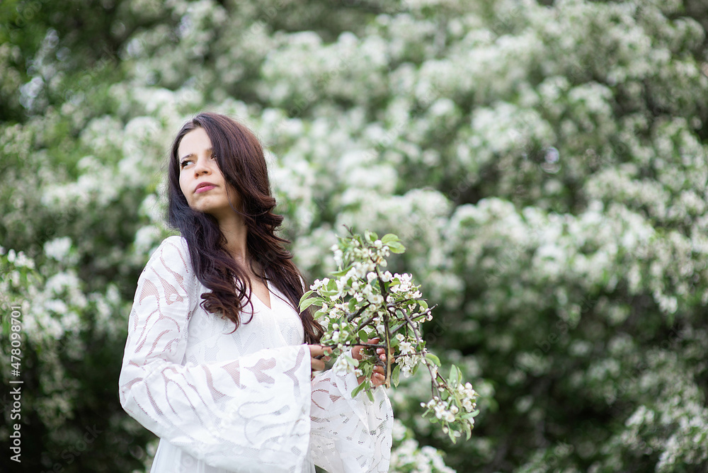 Portrait of a beautiful young woman in the park in the blooming branches at the summer or spring. Portrait of a beautiful young woman in the park in the blooming branches at the summer or spring.