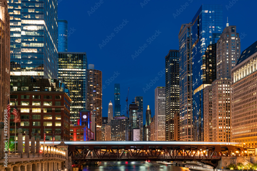 Illuminated night Panorama cityscape of Chicago downtown and River with bridges, Chicago, Illinois, USA. A vibrant business neighborhood