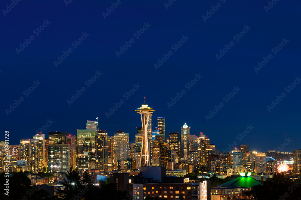 Seattle skyline panorama with iconic view observation tower called Space Needle as seen from Kerry Park. Skyscrapers of financial downtown at night, Washington, USA. A vibrant business neighborhood