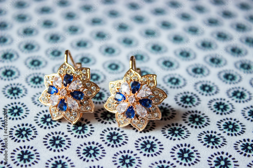 Obraz premium Gold earrings with colorful precious stones jewelry for women isolated on white background, clipping path included