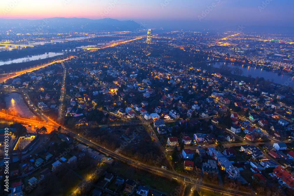 Fototapeta premium Aerial view of Vienna in the evening . Spectacular landscape of city in the dusk . Vienna and Danube river view from above 