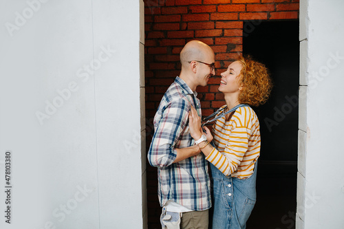 Couple in love inside an apartment under construction, looking at each other