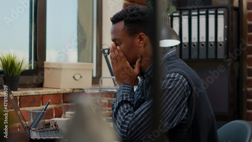 Anxious worker finging put bad news about business project in office. Company accountant worrying about work failure, planning financial report under pressure on laptop. Frustrated man photo