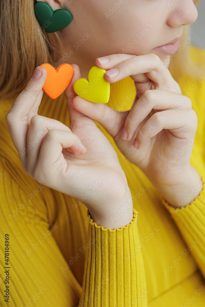 Teenage girl chooses jewelry earrings. Heart shaped earrings. St. Valentine's Day. High quality photo Teenage girl chooses jewelry earrings. Heart shaped earrings. St. Valentine's Day. High quality photo