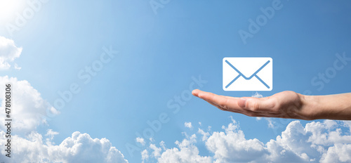 Businessman hand holding e-mail icon, Contact us by newsletter email and protect your personal information from spam mail. Customer service call center contact us concept