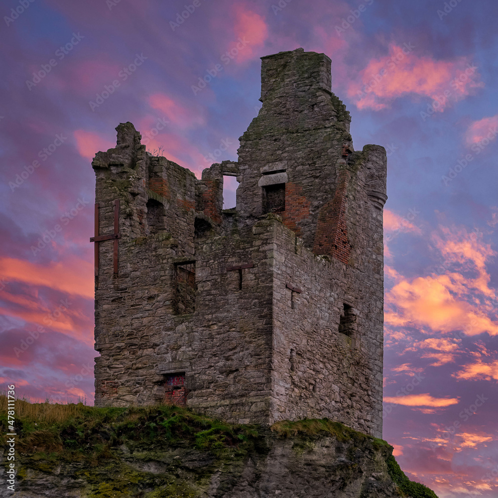 The Crumbling Ancient Ruins of Greenan Castle looking over From Greenan Bay in Ayrshire Scotland with a Red Sunset Sky The Crumbling Ancient Ruins of Greenan Castle looking over From Greenan Bay in Ayrshire Scotland with a Red Sunset Sky