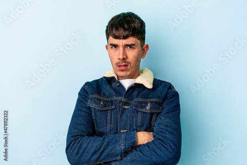 Young mixed race man isolated on blue background who is bored, fatigued and need a relax day. © Asier