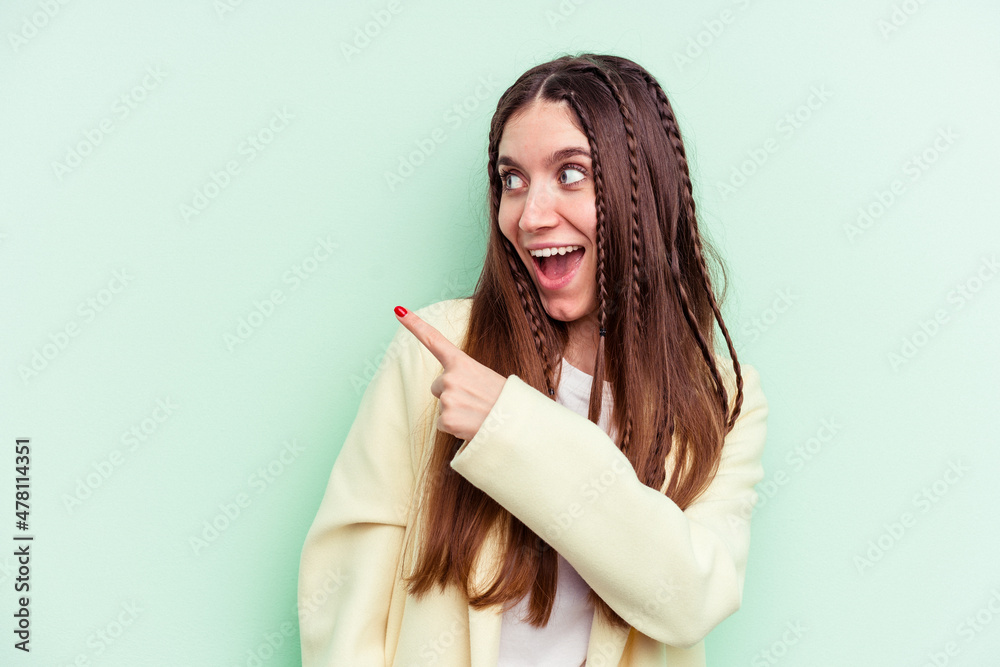 Young caucasian woman isolated on green background looks aside smiling, cheerful and pleasant. Young caucasian woman isolated on green background looks aside smiling, cheerful and pleasant.