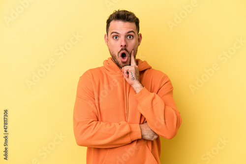 Young caucasian man isolated on yellow background having some great idea, concept of creativity. © Asier