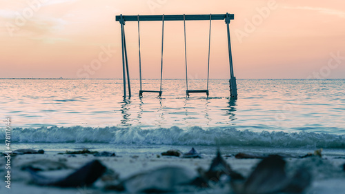 Swing in the sea against the sunset on the beach