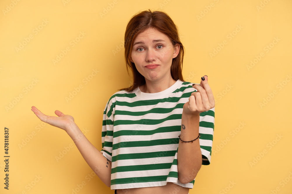 Young English woman isolated on yellow background showing that she has no money. Young English woman isolated on yellow background showing that she has no money.