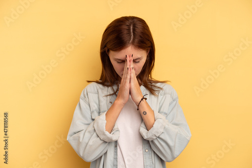 Young English woman isolated on yellow background praying, showing devotion, religious person looking for divine inspiration Fototapete