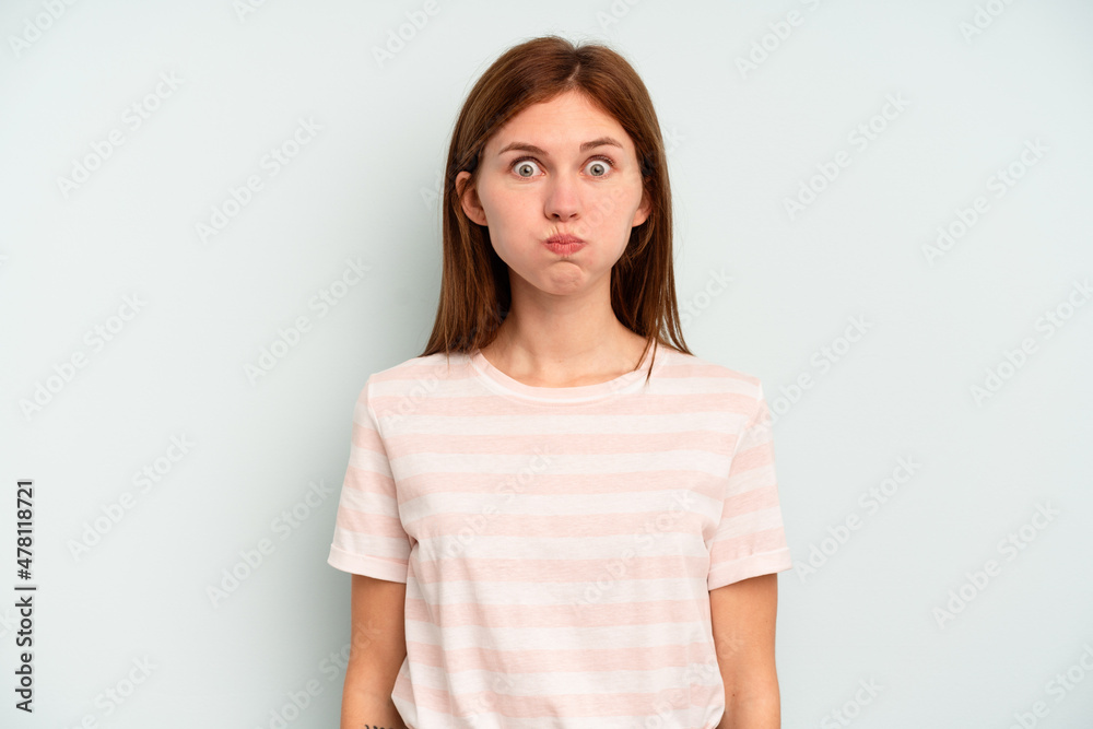 Young English woman isolated on blue background blows cheeks, has tired expression. Facial expression concept. Young English woman isolated on blue background blows cheeks, has tired expression. Facial expression concept.