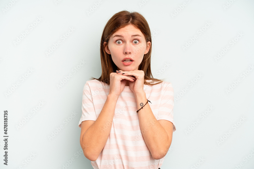Young English woman isolated on blue background praying for luck, amazed and opening mouth looking to front. Young English woman isolated on blue background praying for luck, amazed and opening mouth looking to front.