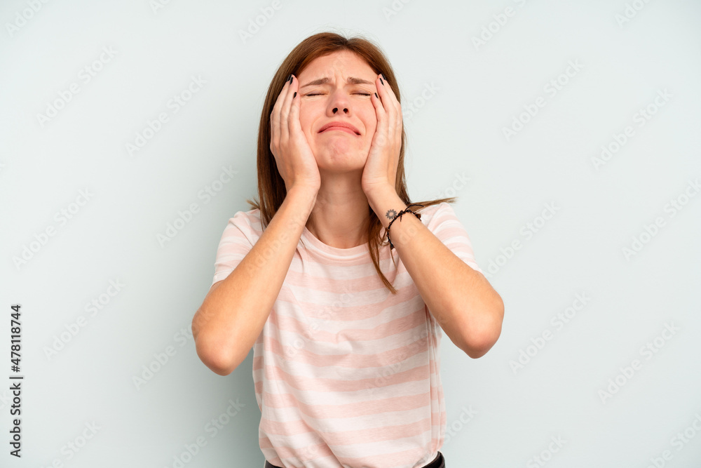 Young English woman isolated on blue background crying, unhappy with something, agony and confusion concept. Young English woman isolated on blue background crying, unhappy with something, agony and confusion concept.