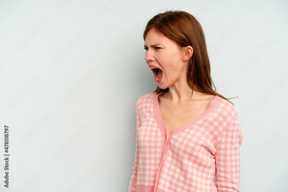 Young English woman isolated on blue background shouting very angry, rage concept, frustrated. Young English woman isolated on blue background shouting very angry, rage concept, frustrated.