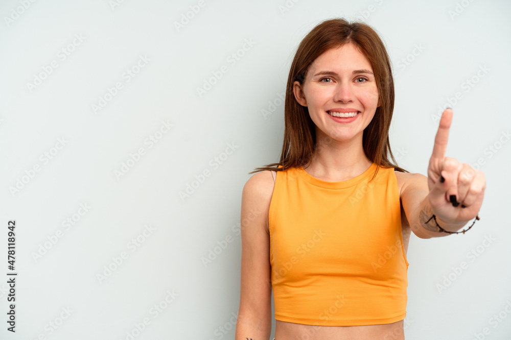 Young English woman isolated on blue background showing number one with finger. Young English woman isolated on blue background showing number one with finger.