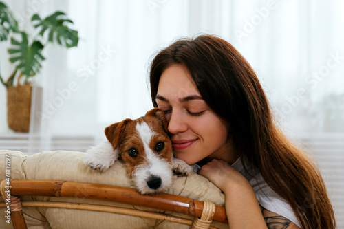 Wallpaper Mural Portrait of young beautiful woman on a papasan chair with her adorable wire haired Jack Russel terrier puppy. Loving girl with rough coated pup having fun. Background, close up, copy space. Torontodigital.ca