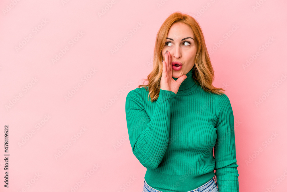 Young caucasian woman isolated on pink background is saying a secret hot braking news and looking aside Young caucasian woman isolated on pink background is saying a secret hot braking news and looking aside