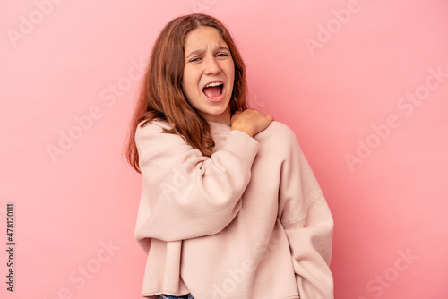 Little caucasian girl isolated on pink background having a shoulder pain. © Asier
