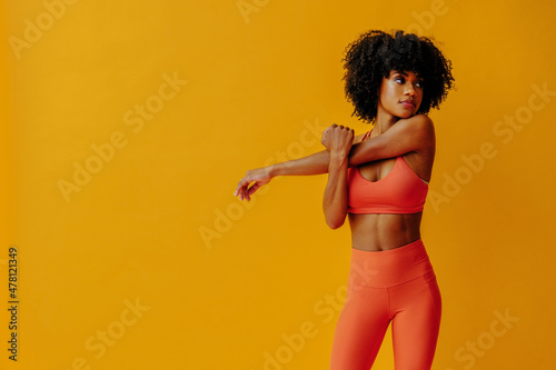 young fit black woman in sportswear posing isolated on yellow background