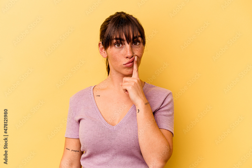 Young Argentinian woman isolated on yellow background thinking and looking up, being reflective, contemplating, having a fantasy. Young Argentinian woman isolated on yellow background thinking and looking up, being reflective, contemplating, having a fantasy.